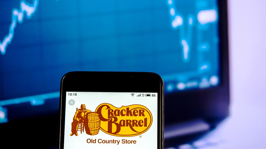 The old Cracker Barrel log on a phone in front of a stock grid.