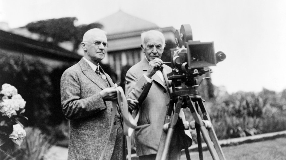 Inventor Thomas Edison and George Eastman pose for a portrait with a motion picture camera at Eastman's house in 1928 in Rochester, New York.