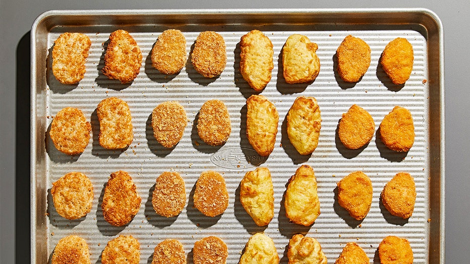 Chicken nuggets lined up on a tray
