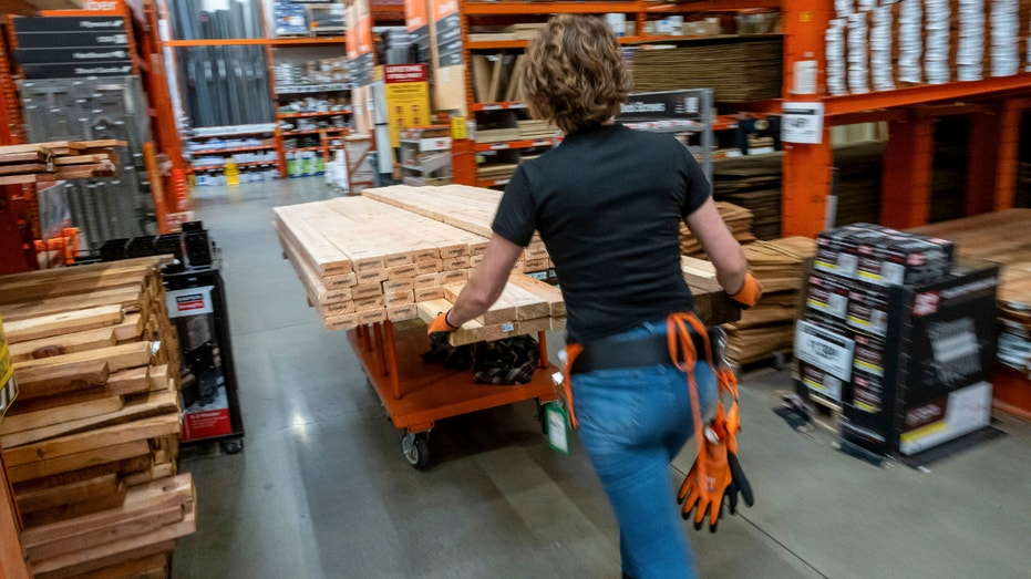 An employee pushes a cart loaded with wood inside a Home Depot store in Roseville, California, on Feb. 24, 2025.