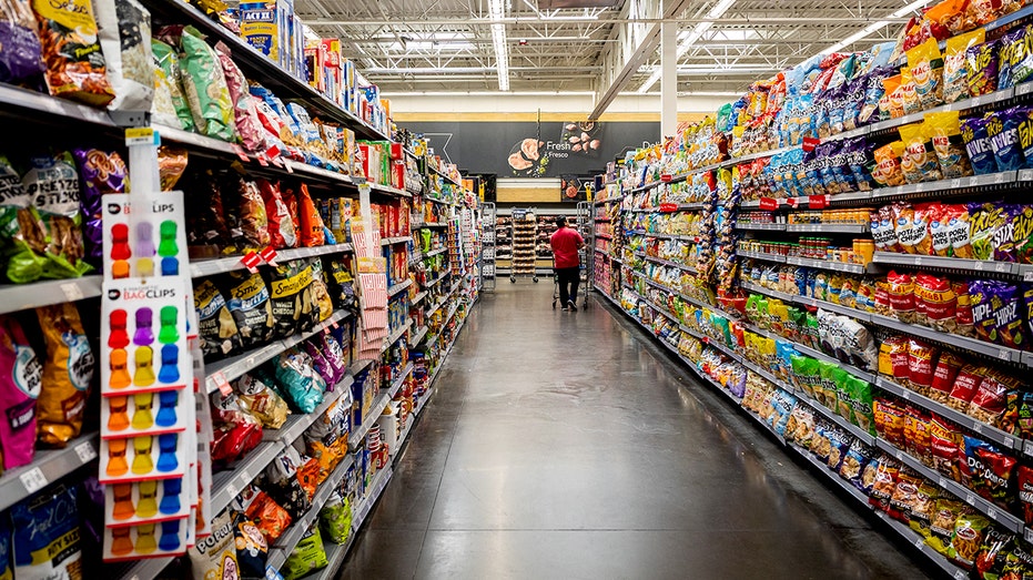 Customer with shopping cart in the snack aisle of a Walmart store in Florida City.