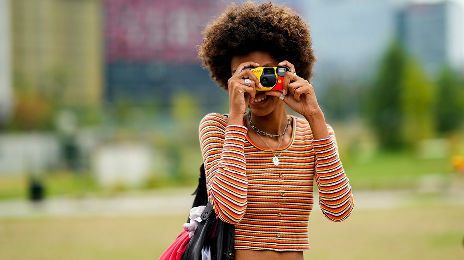 A person using a Kodak disposable camera in Milan.