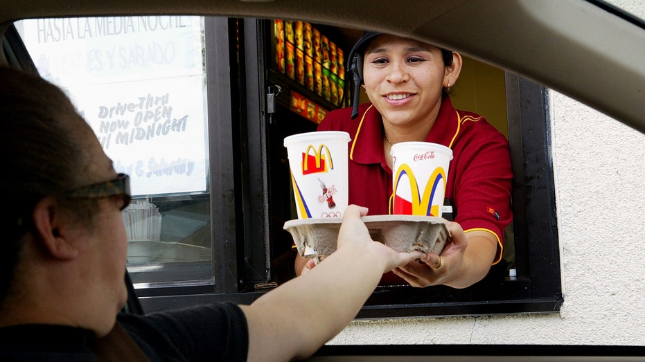 McDonald's worker delivers a tray from drinks to driving through the customer in the city of Redwood, California.