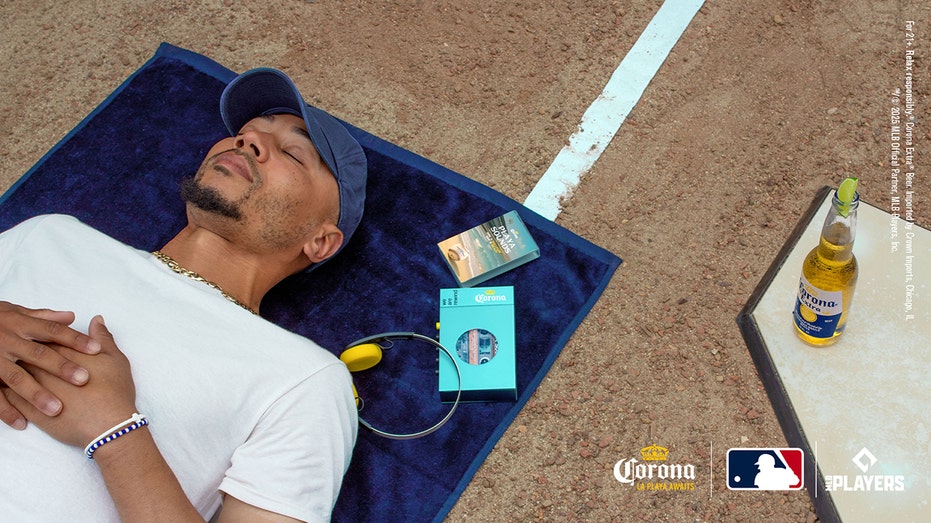 Mookie Betts lying down on field with headphones and Corona