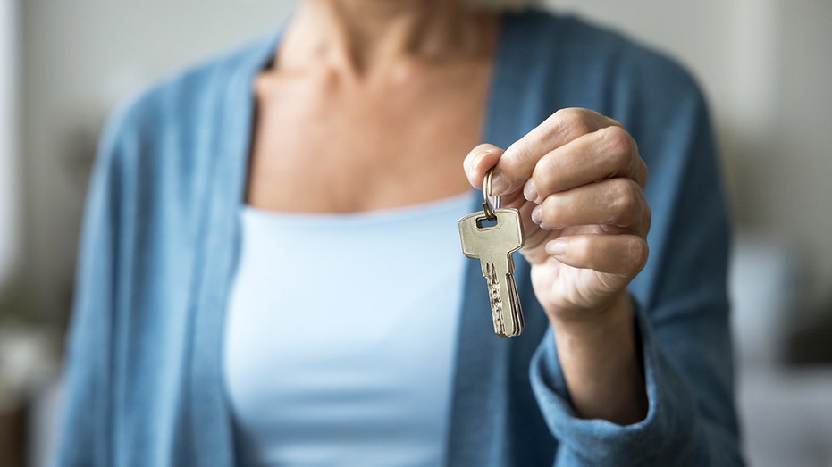 Older woman holds set of keys in her left hand