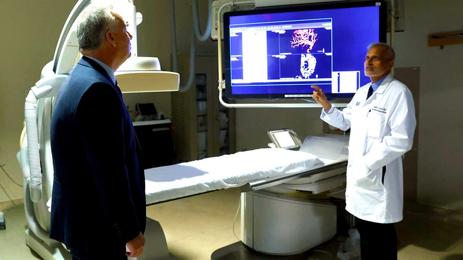 Dr. Baljit Deol, an interventional radiology specialist at the University Medical Center (UMC) next to a Philips Interventional Radiology machine