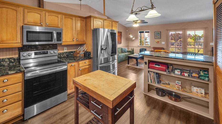 The kitchen features wooden cabinets and granite countertops.
