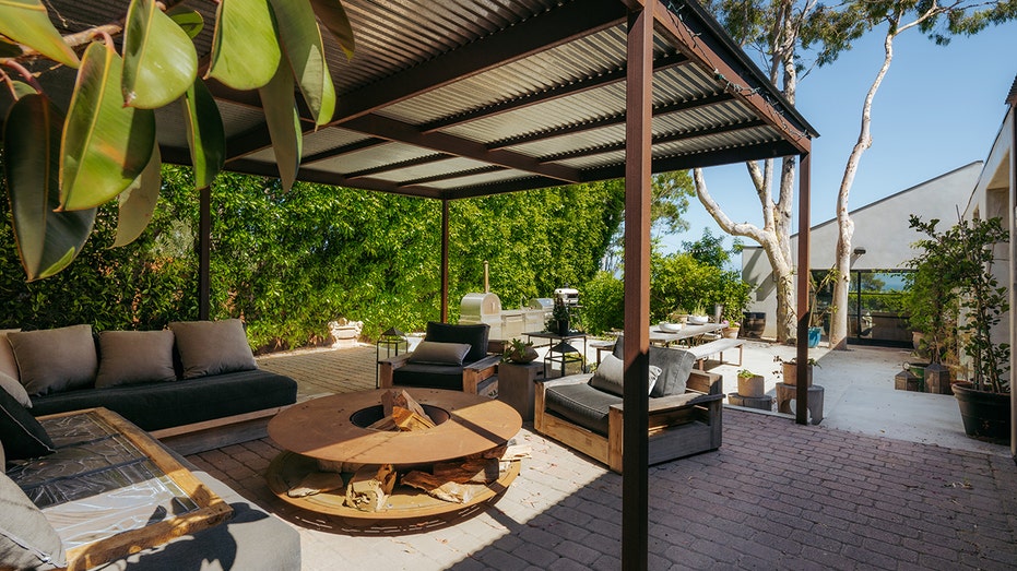 The backyard features a fire pit, outdoor dining area and outdoor kitchen.