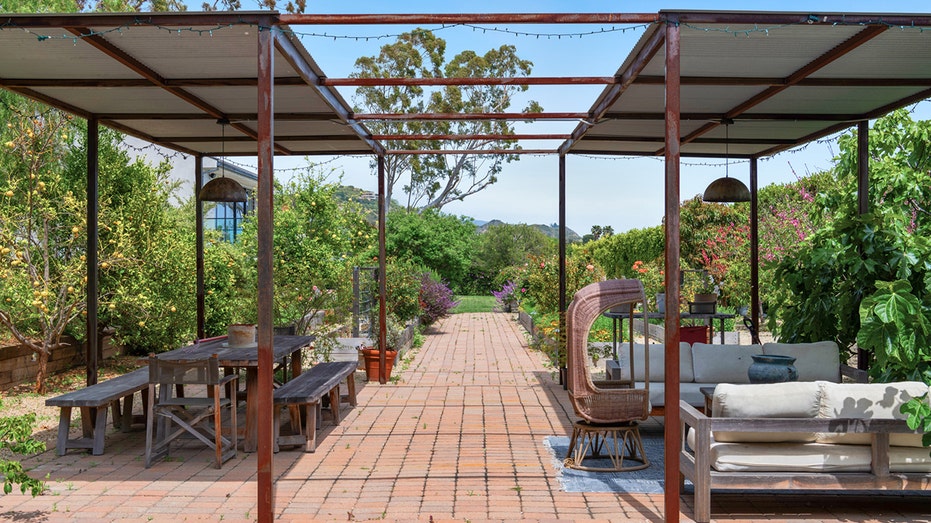 The backyard also features a covered dining area and lounge space.