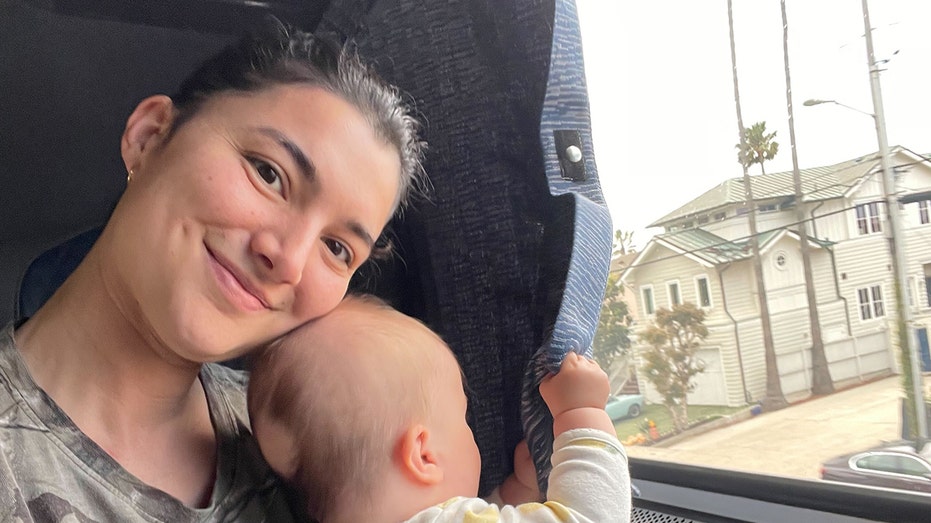 Shayan Wright, who holds her child next to a window, shared a story about the breastfeeding incident at British Airways.