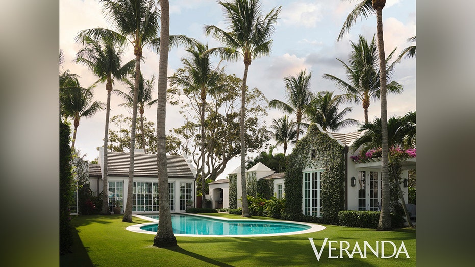 The backyard of the house is characterized by a pool in the key hole and long palm trees.