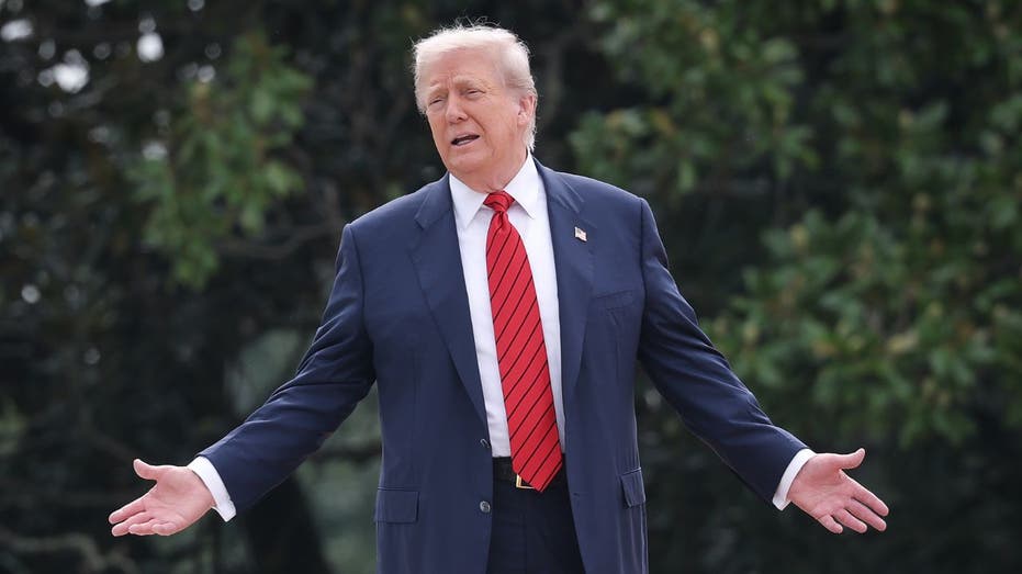 US President Donald Trump stands with his arms open while talking to the correspondents