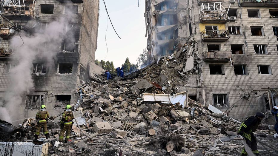 Ukrainian rescuers looking through rumble for survivors following a Russian missile strike