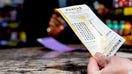 AUSTIN, TEXAS - SEPTEMBER 04: A person holds a Powerball lottery ticket they purchased at the Brew Market &amp; Cafe on September 04, 2025 in Austin, Texas. The Powerball Jackpot has grown to $1.7 billion, positioning it as the third largest prized jackpot in U.S. lottery history. (Photo by Brandon Bell/Getty Images) - Fox Business News