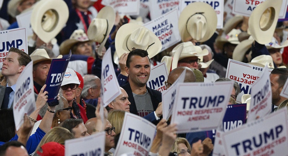 Charlie Kirk surrounded by Trump signs