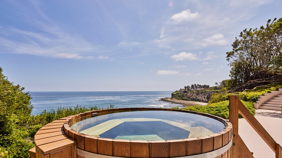 The hot tub has picturesque views of the ocean.