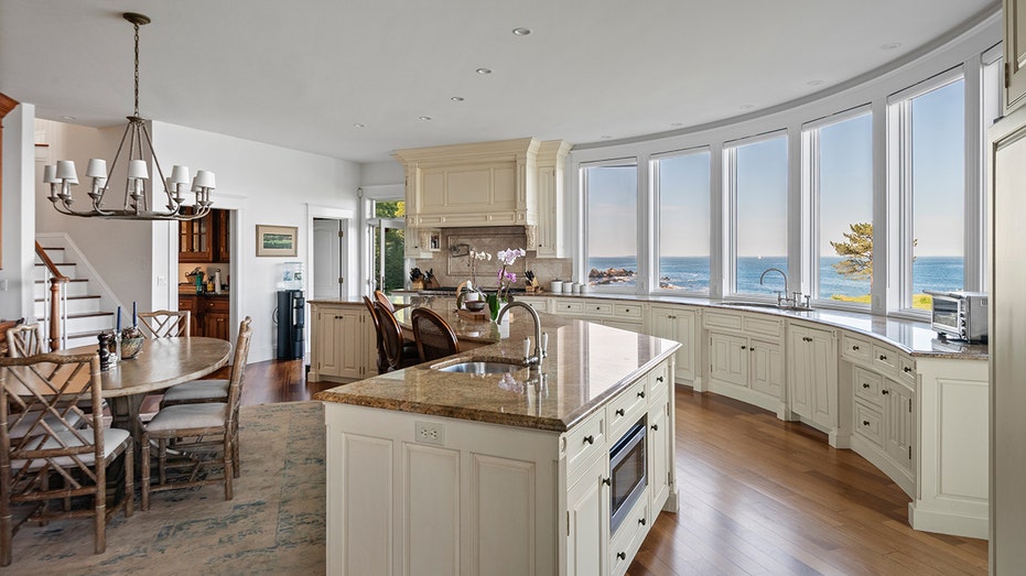 The kitchen boasts a large center eat-in island, a fireplace and views of the ocean.