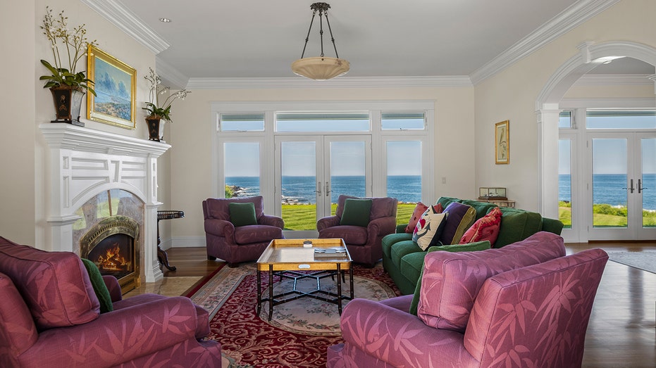 The living room features stunning views of the ocean and a fireplace.