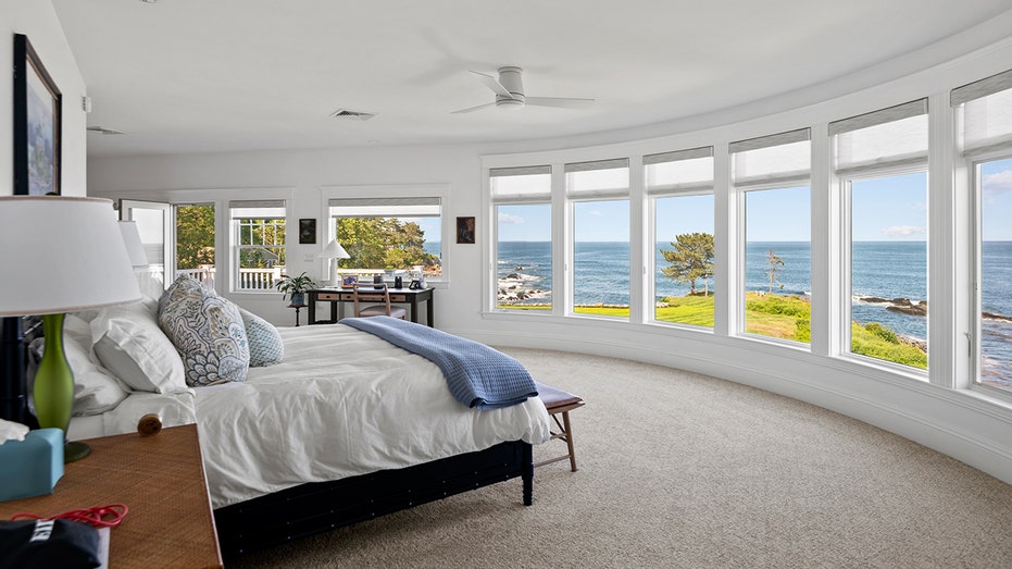 The primary bedroom boasts wall-to-wall windows with picturesque views of the ocean.