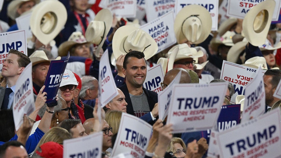 Charlie Kirk surrounded by Trump signs