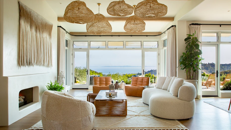 The living room features unique light fixtures and floor-to-ceiling windows.