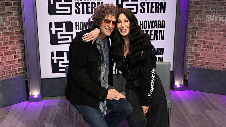 Howard Stern poses for a photo with Cher during her visit to SiriusXM's 'The Howard Stern Show'