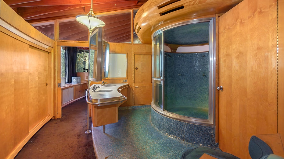 The bathroom shows a curved shower.