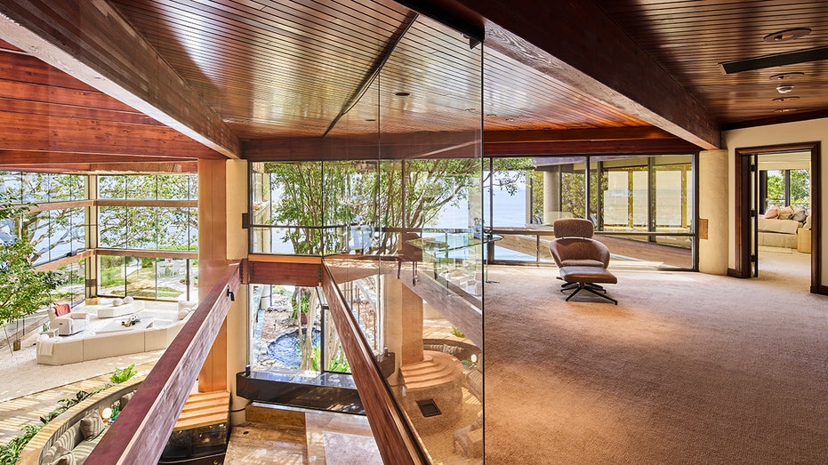 The office is on the upper level with glass windows, giving off the illusion that it is floating.
