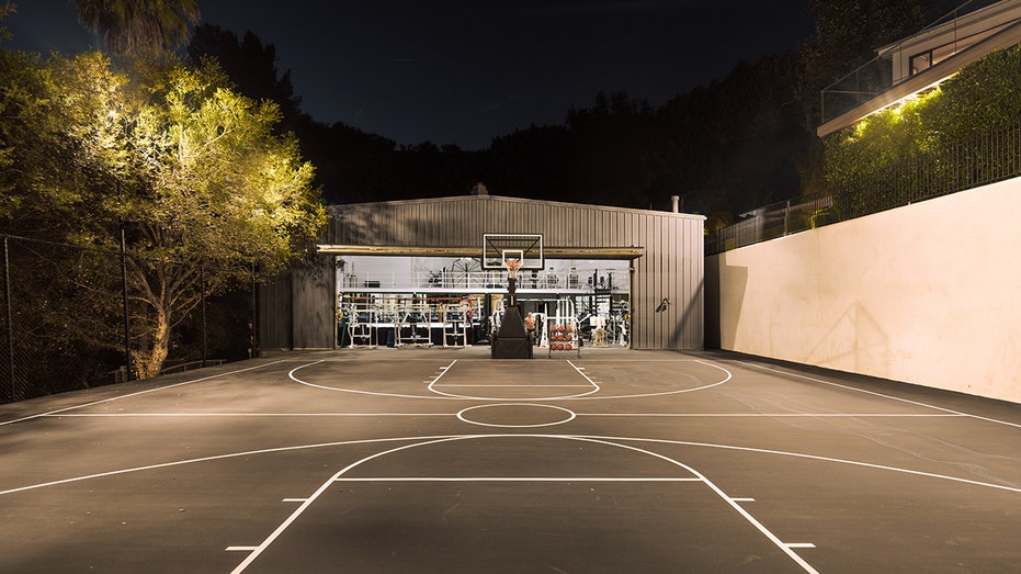 A full basketball court can be found in front of a multi-level gym.