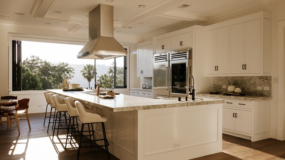The kitchen features an eat-in center island as well as a large refrigerator and a breakfast nook.