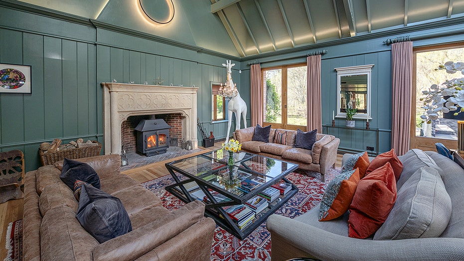 The living room shows green roofs and burning fire.