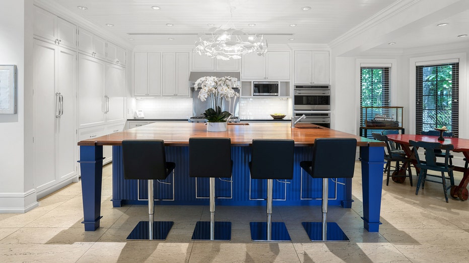 The kitchen features a large center eat-in island and an informal dining area.