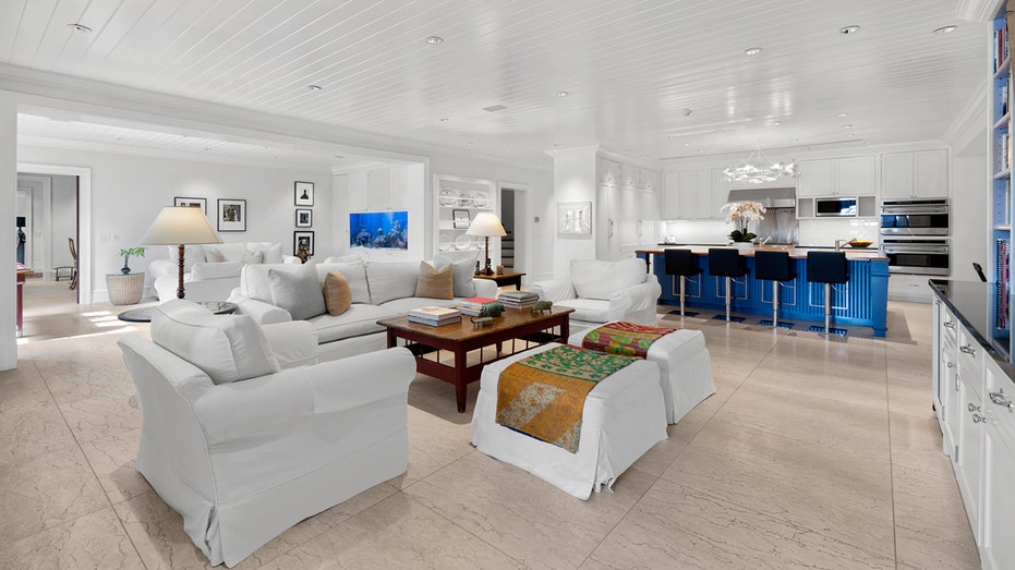 The home features a second sitting room with all white furniture and light hardwood floors.