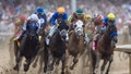 Jockeys and horses race around a muddy track during a major horse race. - Fox News