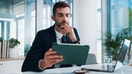 An employee in the office looking at the screen of a tablet. - Fox Business News