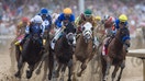 Jockeys and horses race around a muddy track during a major horse race. - Fox Business News