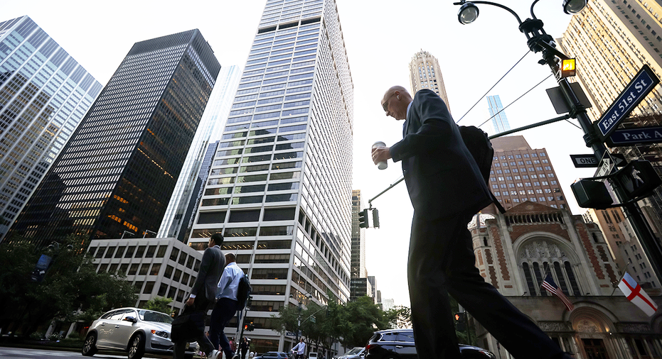 Businessman walking in front of tall buildings