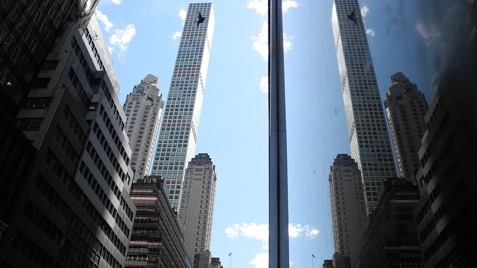 The skyscraper "432 Park Avenue" is reflected in a glass facade.