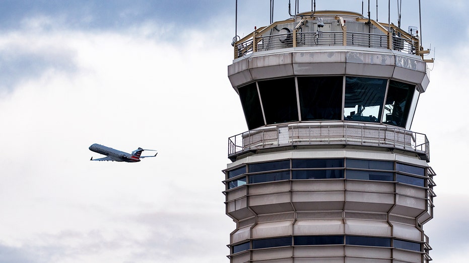 American Eagle plane takes off in Washington, D.C., past air traffic control tower