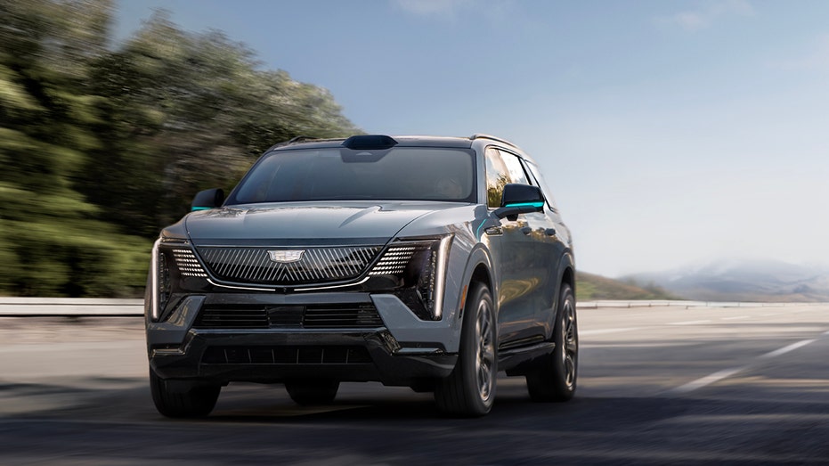 A Cadillac ESCALADE IQ driving down the highway.