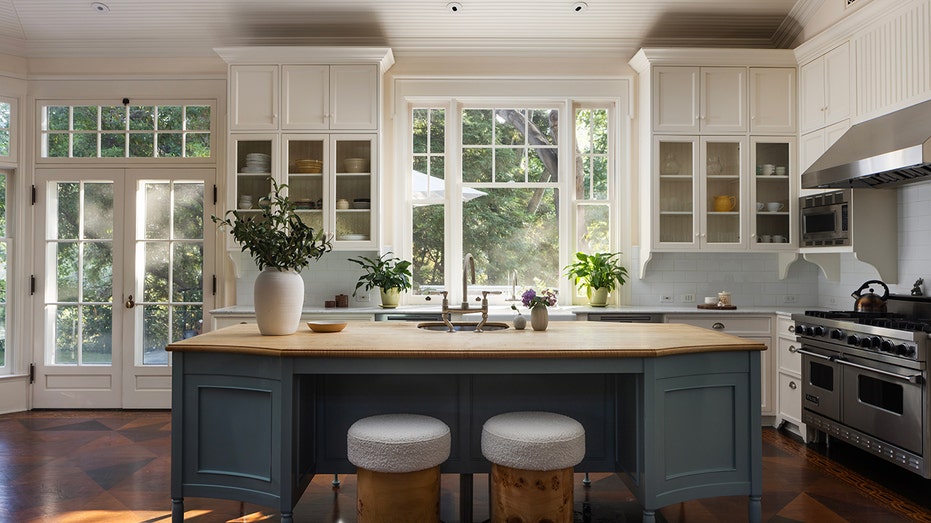 The kitchen includes an architect of central and white cabinets.