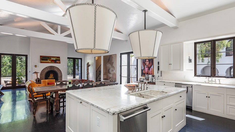 The kitchen features a large center island as well as a dining and lounge area with a fireplace.