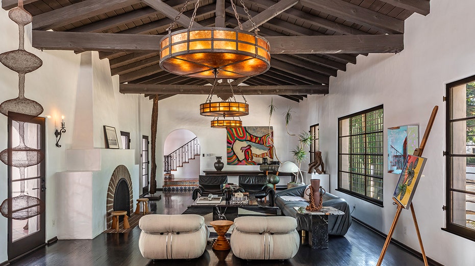The living room features exposed beamed ceilings and a fireplace.