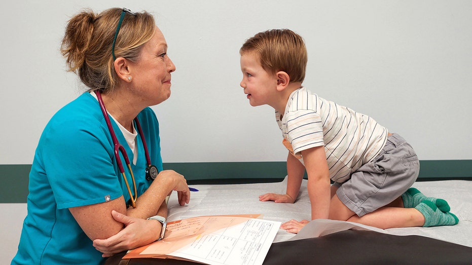 Dr. Pam Trout engages 3-year-old Bennett before his exam.