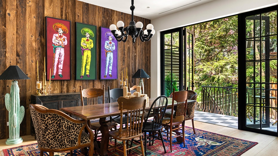 The dining room boasts colorful pictures on the wall and outdoor seating.