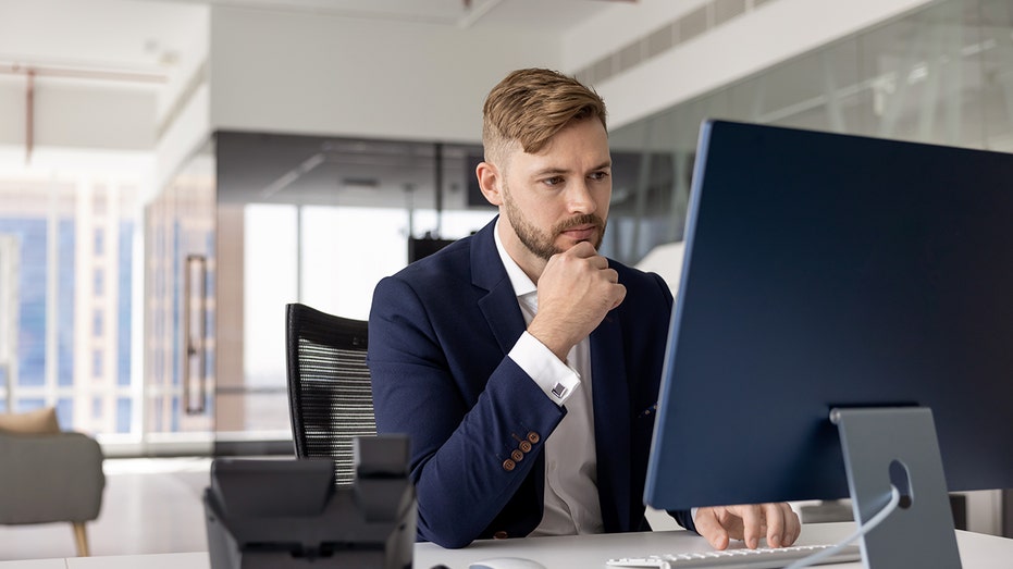 An executive working at desktop in their office.