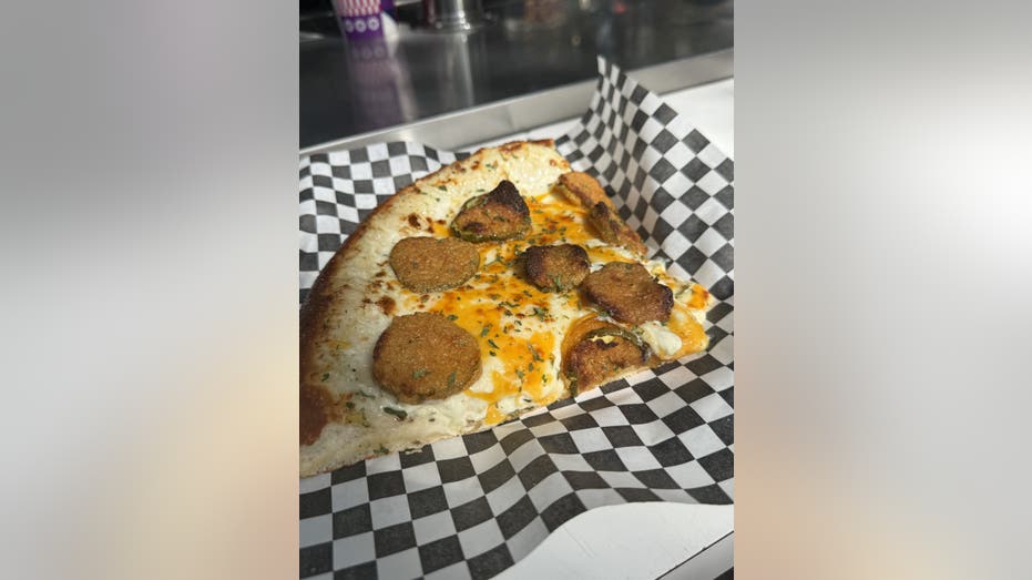 A pizza with fried pickles on a plate.