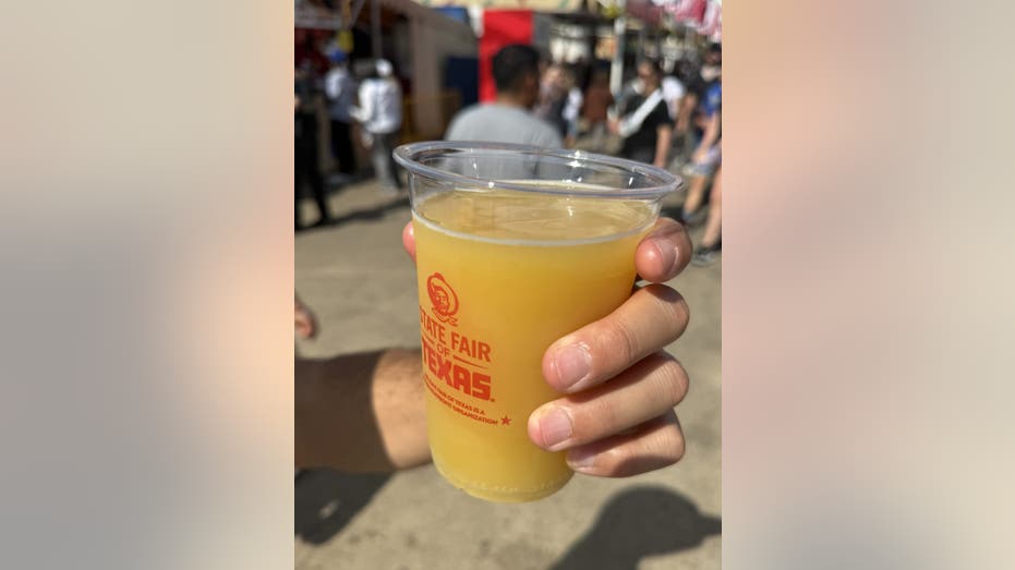 A mustard-flavored beer in a plastic cup.