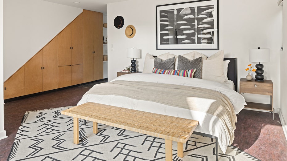 The primary bedroom includes black and white carpet.