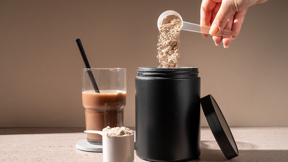 Protein shake and chocolate protein powder in a scoop, food supplement